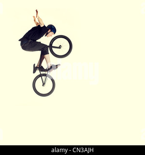 Jeune homme sur vélo BMX, mid air Banque D'Images