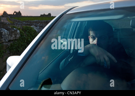 Businessman leaning on volant dans la voiture Banque D'Images