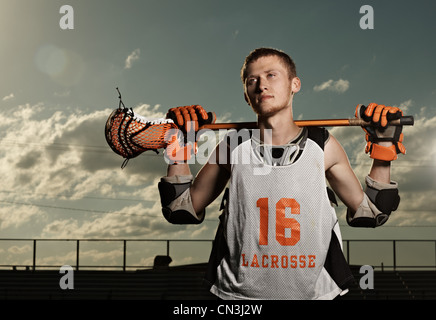 Young sportsman holding bâton de crosse en stadium Banque D'Images