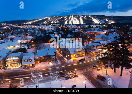 Le Canada, la province du Québec, région des Laurentides, St Sauveur, la ville et à l'arrière-plan des pistes de ski éclairée la nuit Banque D'Images