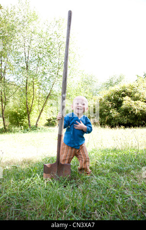 Tout-petit avec grande pelle à jardin Banque D'Images