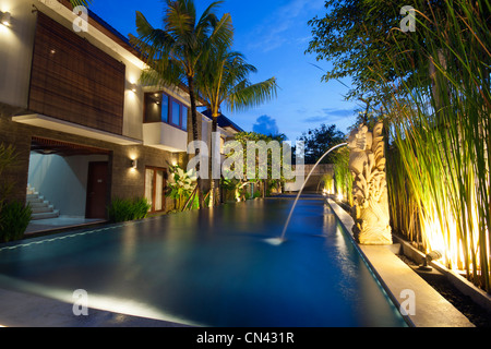 Piscine éclairée inoccupées à Bali au crépuscule Banque D'Images