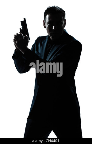 Portrait d'un criminel d'espionnage policier detective man holding gun portrait silhouette en studio isolé sur fond blanc Banque D'Images