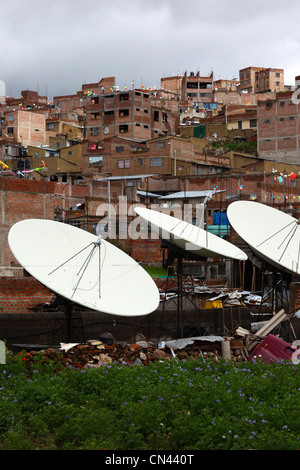 Antennes paraboliques de télévision par satellite et maisons en briques sur la colline dans la banlieue, Puno, Pérou Banque D'Images