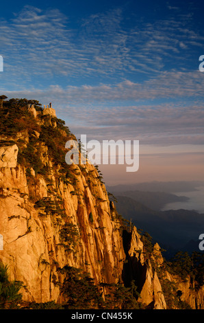 Visiteur sur Lion Peak Lookout au lever du soleil avec du brouillard en vallée à Huangshan montagne jaune République populaire de Chine Banque D'Images