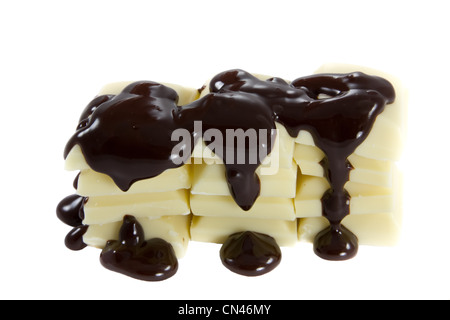 Photo de quelques morceaux de chocolat blanc avec chocolat versé sur Banque D'Images