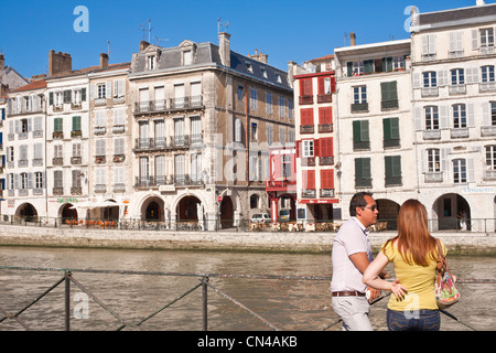 France, Pyrenees Atlantiques, Bayonne, Quai Galuperie, couple en face de maisons traditionnelles sur les rives de la rivière Nive Banque D'Images