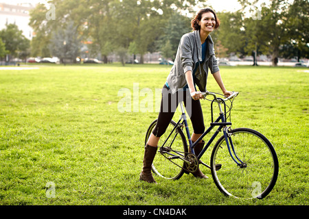 Jeune femme à bicyclette dans le parc Banque D'Images