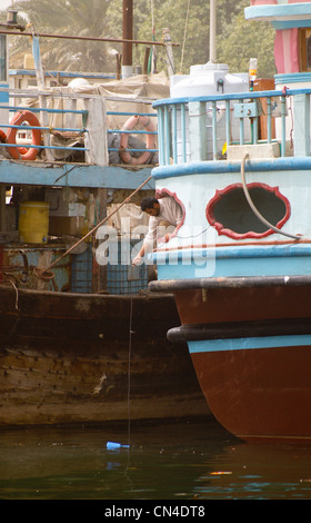 Un marin à la collecte de l'eau d'un dhow à la Crique de Dubaï, Dubaï, Émirats Arabes Unis Banque D'Images