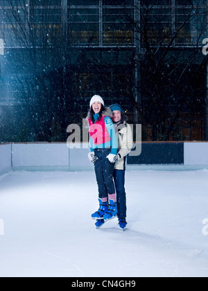 Femme Homme tenant au-dessus de la glace tout en patinant Banque D'Images