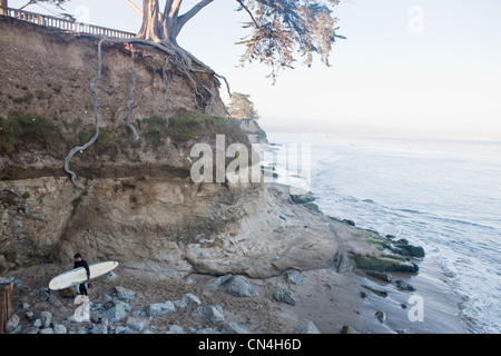 Lone surfer on Rocky beach Banque D'Images