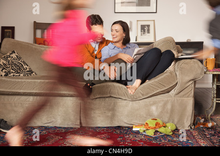 Young couple relaxing on sofa with déménagement autour d'eux Banque D'Images