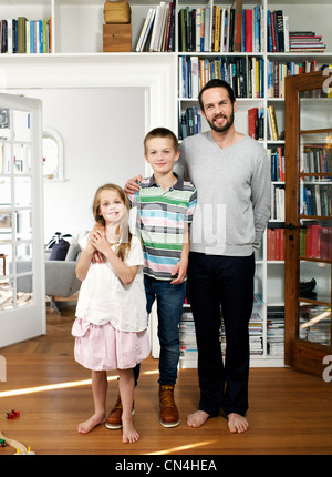 Père et de la famille se tenant ensemble dans la salle de séjour, portrait Banque D'Images