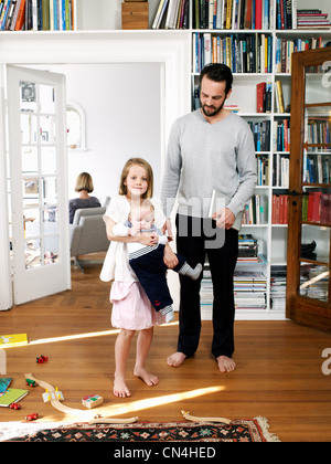 Père et de la famille se tenant ensemble dans la salle de séjour, portrait Banque D'Images