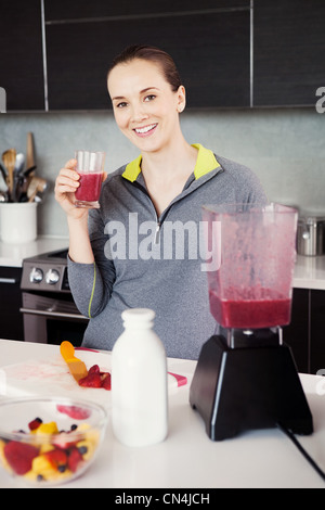 Femme avec un verre de smoothie fraîchement préparés Banque D'Images