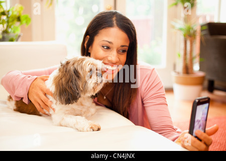 Woman taking photo d'elle-même et son chien de compagnie sur smartphone Banque D'Images
