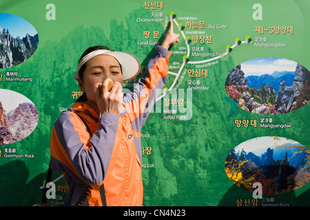 La Corée du Nord, la province de Gangwon, région touristique Kumgangsan, jeune femme guide de la Corée du Nord montrant le chemin de l'Manmulsang Banque D'Images