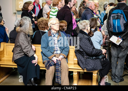 Les personnes âgées assis à écouter le commentaire sur écouteurs au British Museum de Londres, Angleterre Banque D'Images