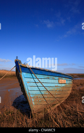 Un sol en bois bleu bateau sous un ciel bleu à Brancaster Staithe sur la côte nord du comté de Norfolk. Banque D'Images