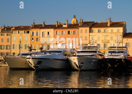 La France, Var, Saint Tropez, le port, des façades de maisons à l'ocre, jaune ou orange en face de l'luxueux yachts Banque D'Images