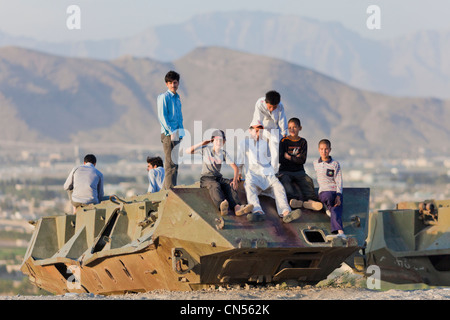 L'Afghanistan, Kaboul, Bibi Maru Hill, les garçons jouant sur l'épave d'un tank russe Banque D'Images
