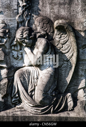 Sculpture d'un ange endormi sur une vieille pierre tombale. Banque D'Images