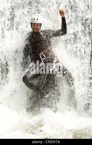 Homme adulte en ordre décroissant dans une cascade de tirer le niveau d'eau Banque D'Images