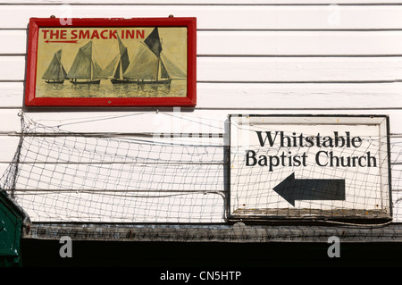 Les panneaux pour le Smack Inn et Église baptiste sur un bâtiment dans High Street, Whitstable Kent. Banque D'Images