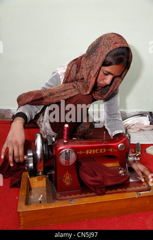 Dehradun, Inde. Femme musulmane indienne travaillant avec le manuel d'instructions de couture machine à coudre dans la classe. Banque D'Images