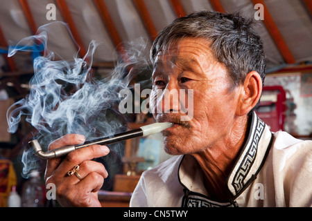 L'homme de Mongolie fumeurs avec tuyau traditionnel , khuduu, Aral khentii province, Mongolie Banque D'Images