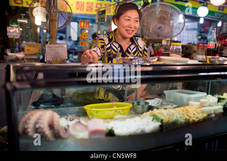 La Corée du Sud, Séoul, District de Dongdaemun, femme travaillant à un food du marché couvert Banque D'Images