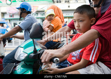 Les familles sur les motos d'attendre aux feux de circulation près du Marché Central, Songkhla, Thaïlande, Jan 2008 Photo de Mike Goldwater Banque D'Images