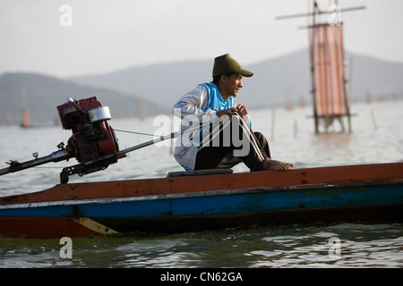 Les pêcheurs à l'aube de recueillir leurs prises de cages a donc chuté sur le lit du lac Songkhla. Banque D'Images