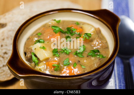 Un bol de soupe au poulet et une tranche de pain complet sur un bambou. Banque D'Images