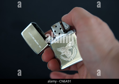 Briquet Zippo American Eagle et ouvert qui se tient à une main Banque D'Images