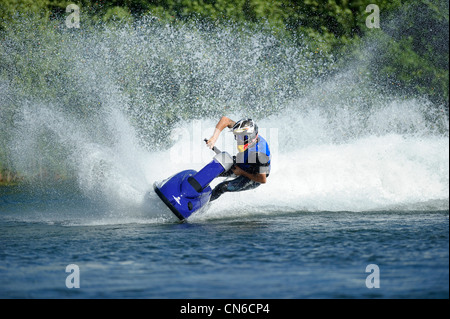 Jet ski sur le lac avec un jet d'eau derrière Banque D'Images