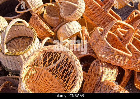 Panier à la main dans des sacs empilés dans la rue en dehors de vendre pile juste. Banque D'Images