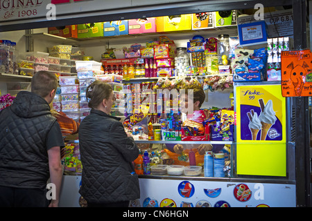 Dame au service de clients dans un décrochage doux dans un marché intérieur à Warrington, Cheshire, Royaume-Uni Banque D'Images