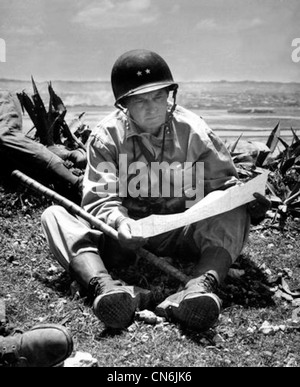 Avec la capitale capturée de Naha comme arrière-plan, le général de division marine Lemuel Shepherd, commandant général de la 6e Division marine, se détend sur une crête d'Okinawa assez longue pour consulter une carte du terrain. Env. Juin 1945 Banque D'Images