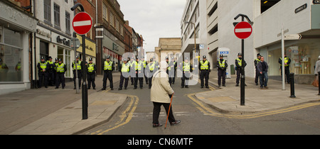 Une vieille femme marche devant un cordon de police pour les Libéraux Démocrates conférence à Sheffield Banque D'Images