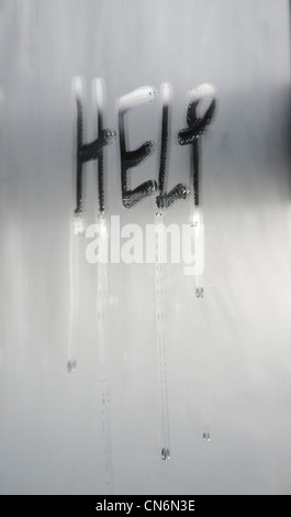 Aider écrit dans la condensation sur un miroir est embuée. Banque D'Images