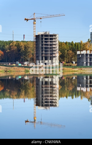 La réflexion et la construction de la grue dans le lac Banque D'Images