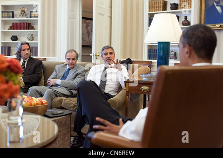 Le président Barack Obama répond à l'écoute de l'acteur et activiste George Clooney dans le bureau ovale de la Maison Blanche le 15 mars 2012 à Washington, DC. Banque D'Images
