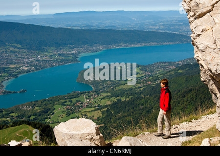 Le randonneur à la recherche d'un étroit sentier dans la montagne pour bornes le lac d'Annecy, Annecy, Haute-Savoie, France Banque D'Images