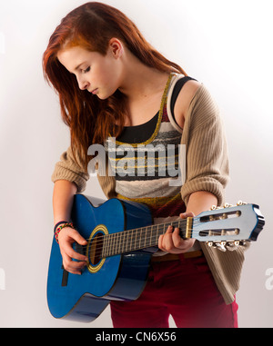 Une adolescente de 13 ans jouant une guitare acoustique, UK Banque D'Images