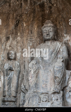 Sculptures en pierre de Bouddha et ses disciples au milieu grotte Binyang dans les grottes de Longmen site en Chine Banque D'Images