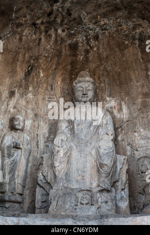 Sculptures en pierre de Bouddha et ses disciples au milieu grotte Binyang dans les grottes de Longmen site en Chine Banque D'Images