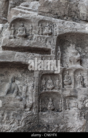 Sculptures en pierre de Bouddha et ses disciples au milieu grotte Binyang dans les grottes de Longmen site en Chine Banque D'Images
