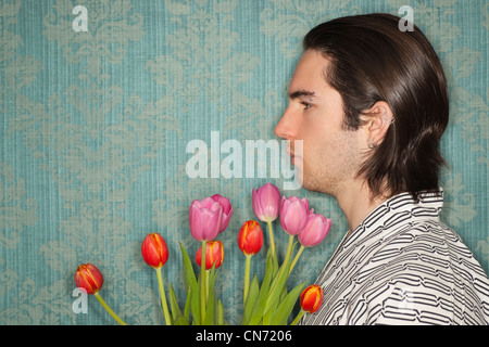 Vue latérale du young caucasian homme portant des vêtements japonais et la tenue des fleurs. Banque D'Images