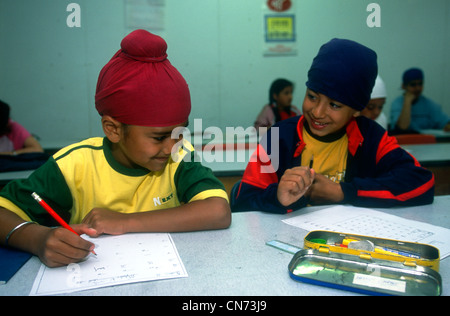 Les enfants sikhs en classe à l'apprentissage de langue pendjabi, le gurdwara Sri Guru Singh Sabha, Hounslow, Middlesex, Royaume-Uni. Banque D'Images